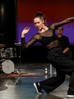 Tänzerin mit Musiker*innen im Hintergrund